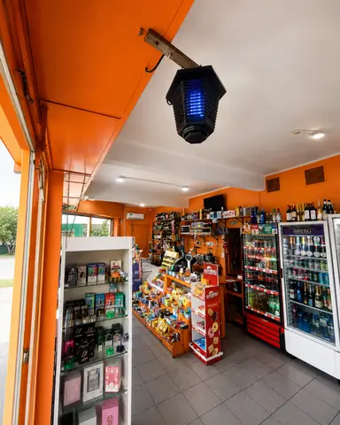 Salon de Manolito, paredes naranjas, vitrina y heladeras de bebidas