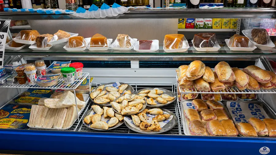 Vitrina con sandwiches de miga, empanadas y dulces