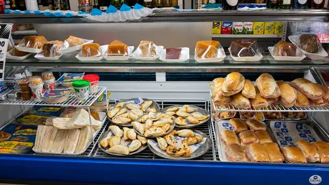 Vitrina con sandwiches de miga, empanadas y dulces